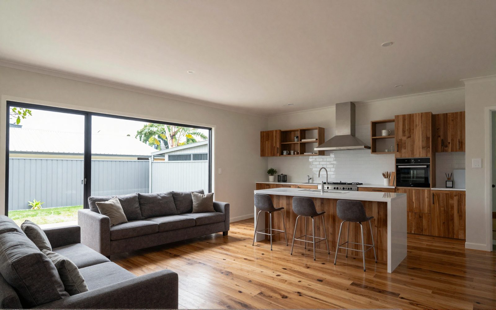 Illustration: an open-plan living room and kitchen with high ceilings and a large window, a split system on the far wall